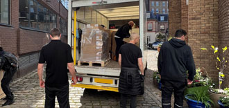 Installify van and man crew unloading office furniture from a truck tail lift