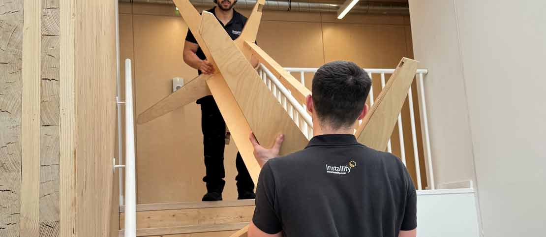 Office relocation team moving furniture and IT equipment inside a London business workspace.